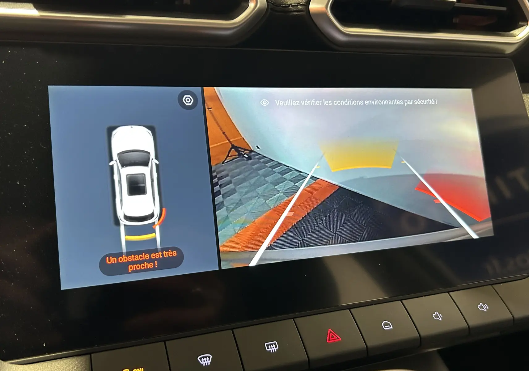 Écran central du MG ZS Hybrid+ 2025 montrant la caméra de recul avec alerte d’obstacle proche en vue arrière.