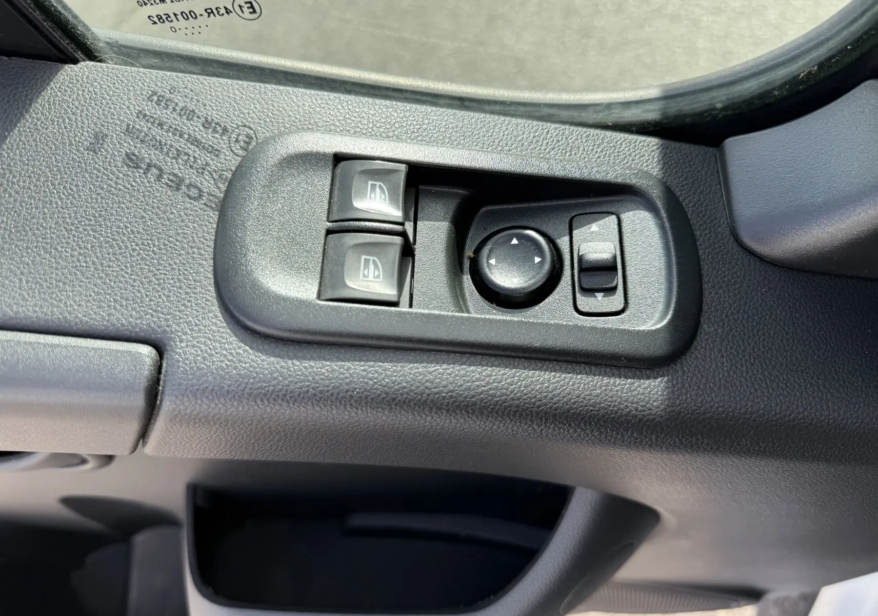 Gros plan sur les commandes électriques des vitres et rétroviseurs côté gauche du Renault Master blanc 2020.