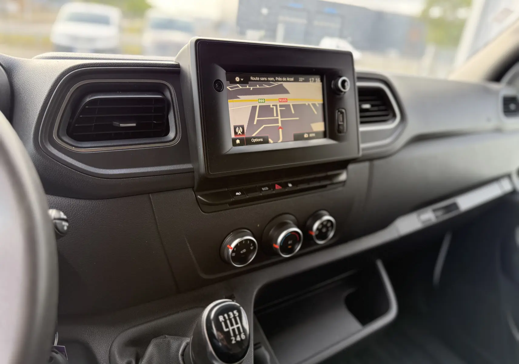 Tableau de bord noir du Renault Master 2020, vue intérieure centrée sur l'écran GPS et levier de vitesses manuel.