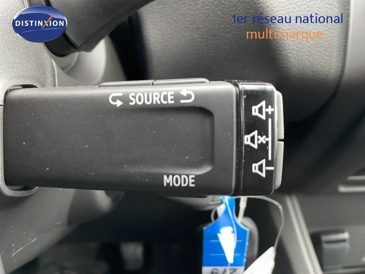 Gros plan sur la commande au volant du Renault Captur noir étoile métal, avec boutons source et mode visibles.