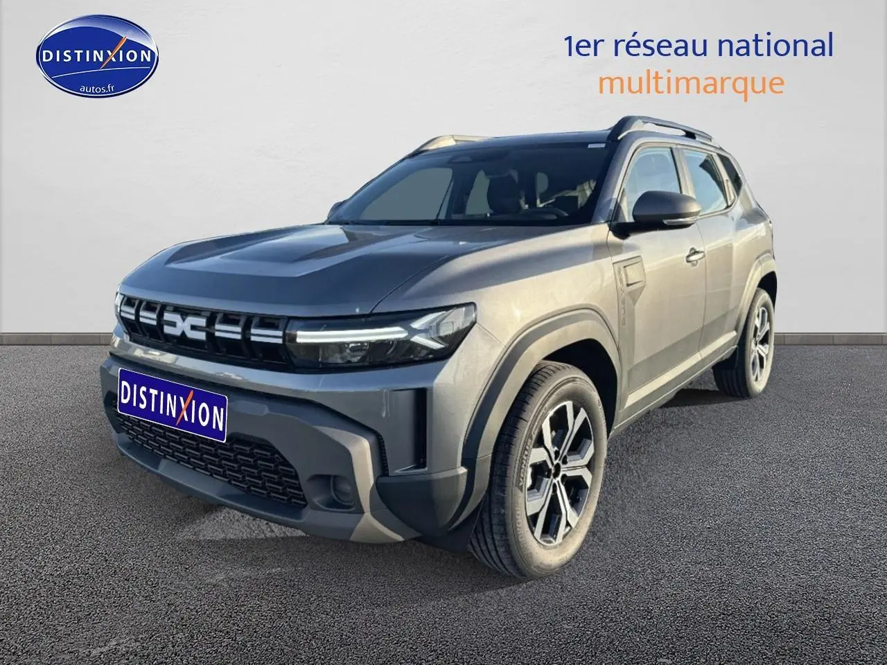 Vue 3/4 avant droite du Dacia Duster gris schiste avec calandre distinctive et jantes alu modernes.