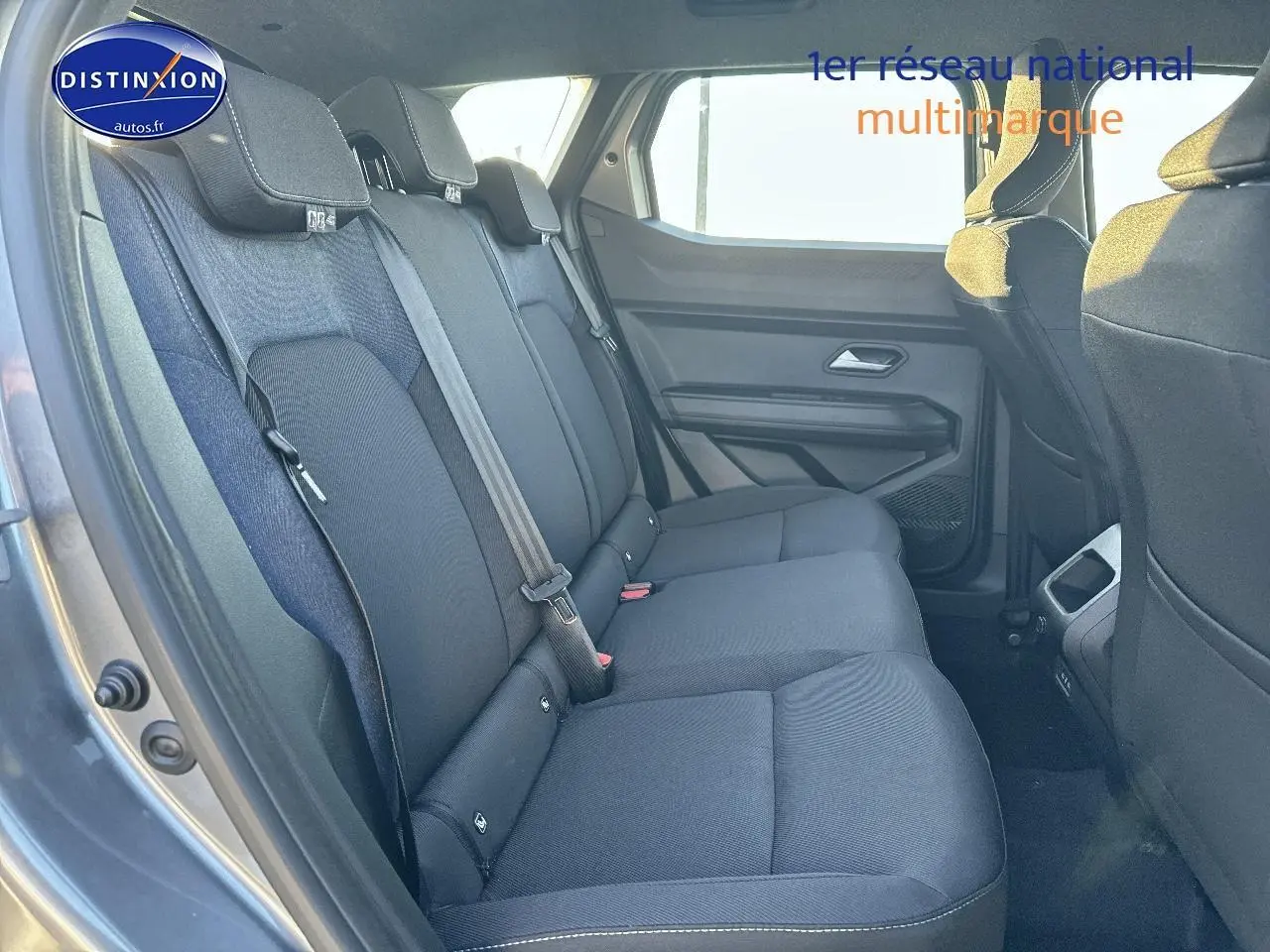 Vue intérieure côté gauche sur la banquette arrière noire du Dacia Duster 2025 gris schiste avec appuie-têtes et ceintures visibles.