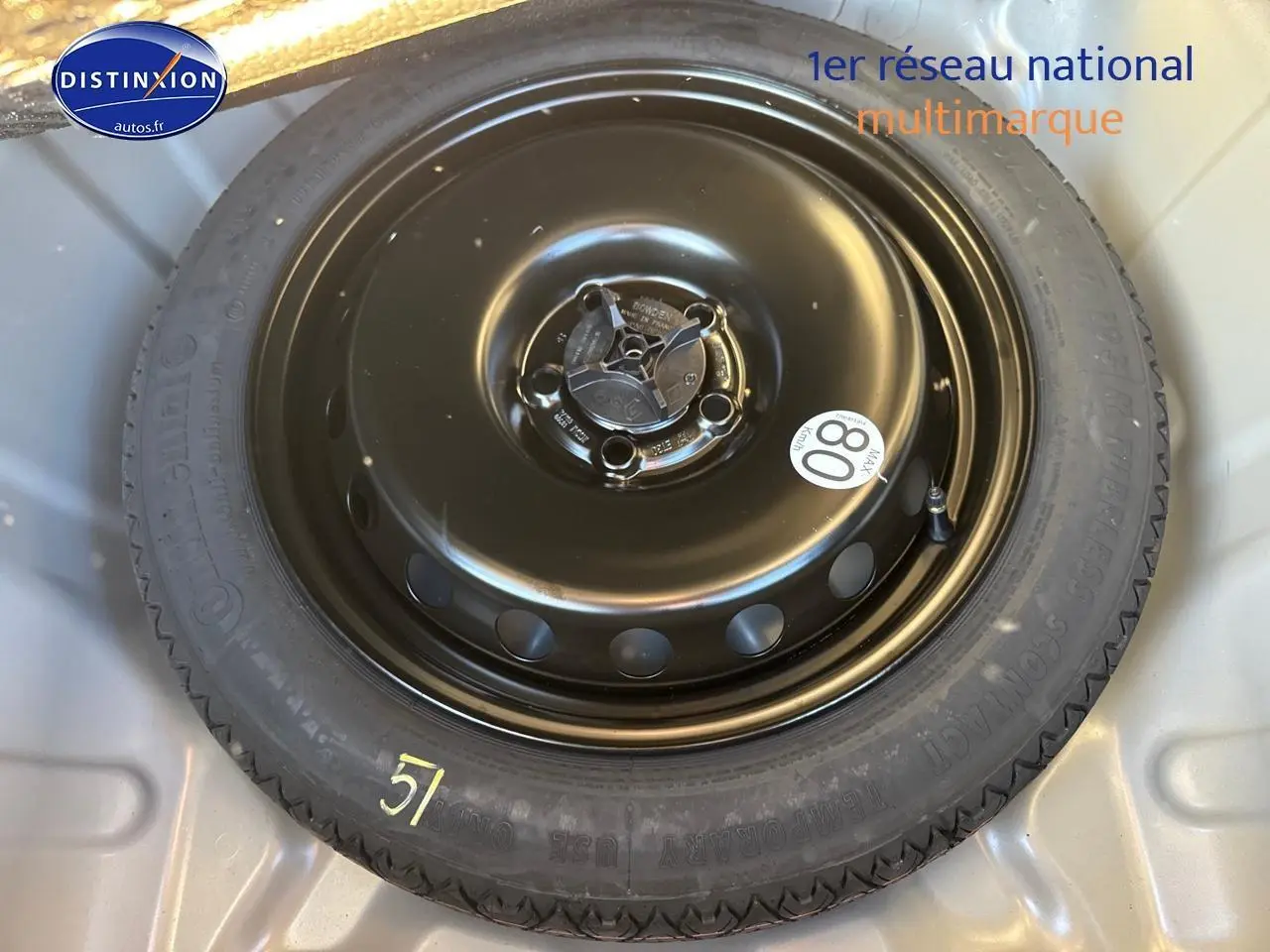 Roue de secours noire en gros plan dans le coffre du Dacia Duster gris schiste 2025.