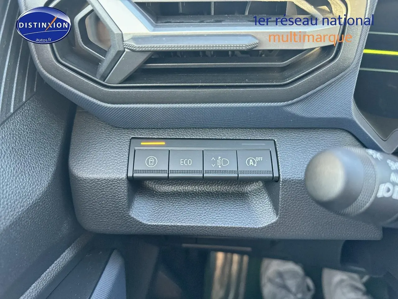 Boutons de commande sur tableau de bord du Dacia Duster gris schiste, vue rapprochée côté gauche sous l'aération.