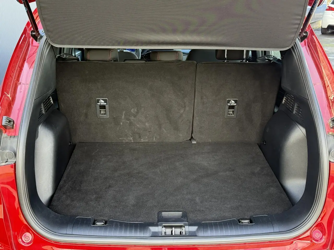 Coffre ouvert vu de l'arrière du Ford Kuga rouge Lucifer 2024, montrant l'espace de chargement vide.