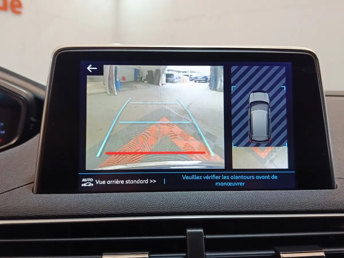 Écran tactile intérieur montrant la caméra de recul et l’aide au stationnement du Peugeot 3008 bleu.