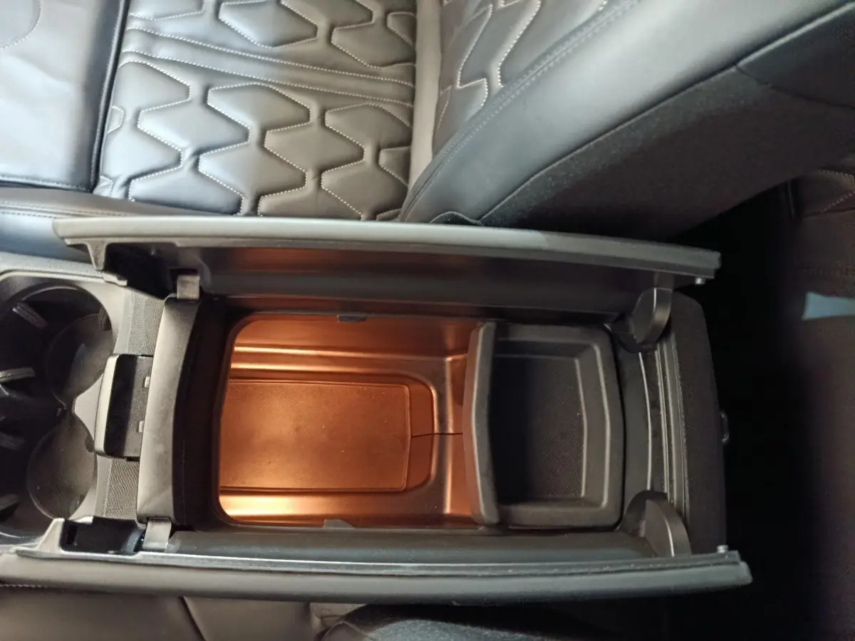 Vue plongeante sur le rangement réfrigéré noir entre les sièges en cuir noir du Peugeot 3008 hybride rechargeable.