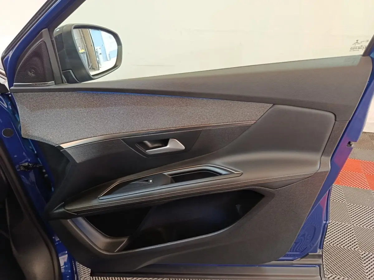 Vue intérieure de la porte avant gauche bleu du Peugeot 3008 1.6 Hybrid 225 GT Pack avec garniture noire et grise.