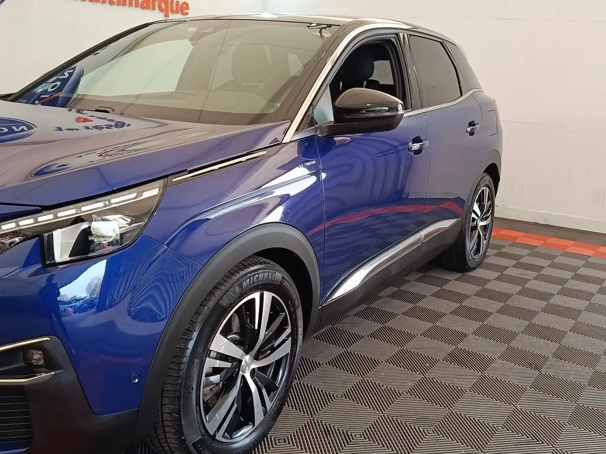 Vue 3/4 avant droit d’un Peugeot 3008 bleu hybride rechargeable avec jantes alliage et rétroviseurs noirs.