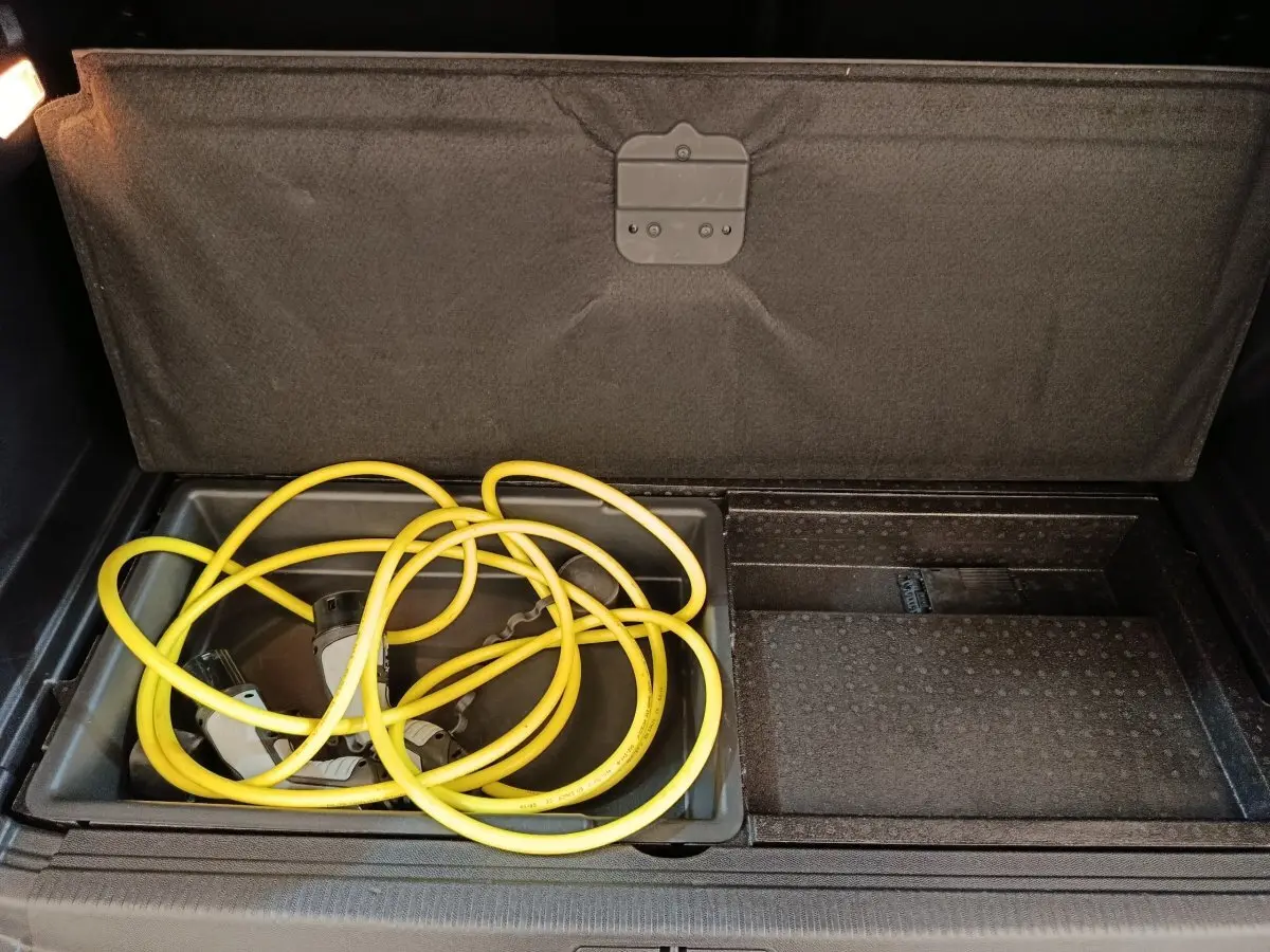 Coffre ouvert du Peugeot 3008 hybride rechargeable 2020, montrant le câble de recharge jaune rangé sous le plancher.