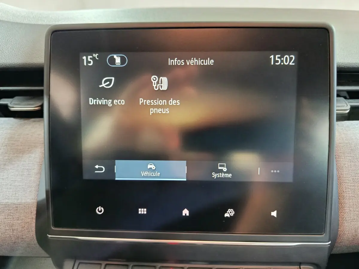 Écran tactile central affichant les infos véhicule d'une Renault Clio noire, vue rapprochée de l'intérieur.