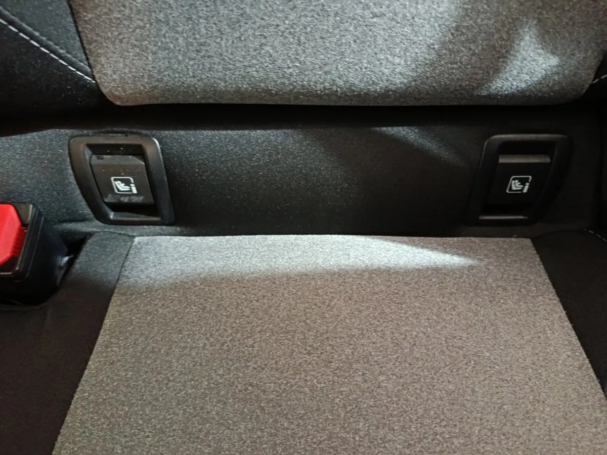 Détail de la banquette arrière noire de la Renault Clio Evolution Blue dCi 100 avec commandes Isofix visibles.