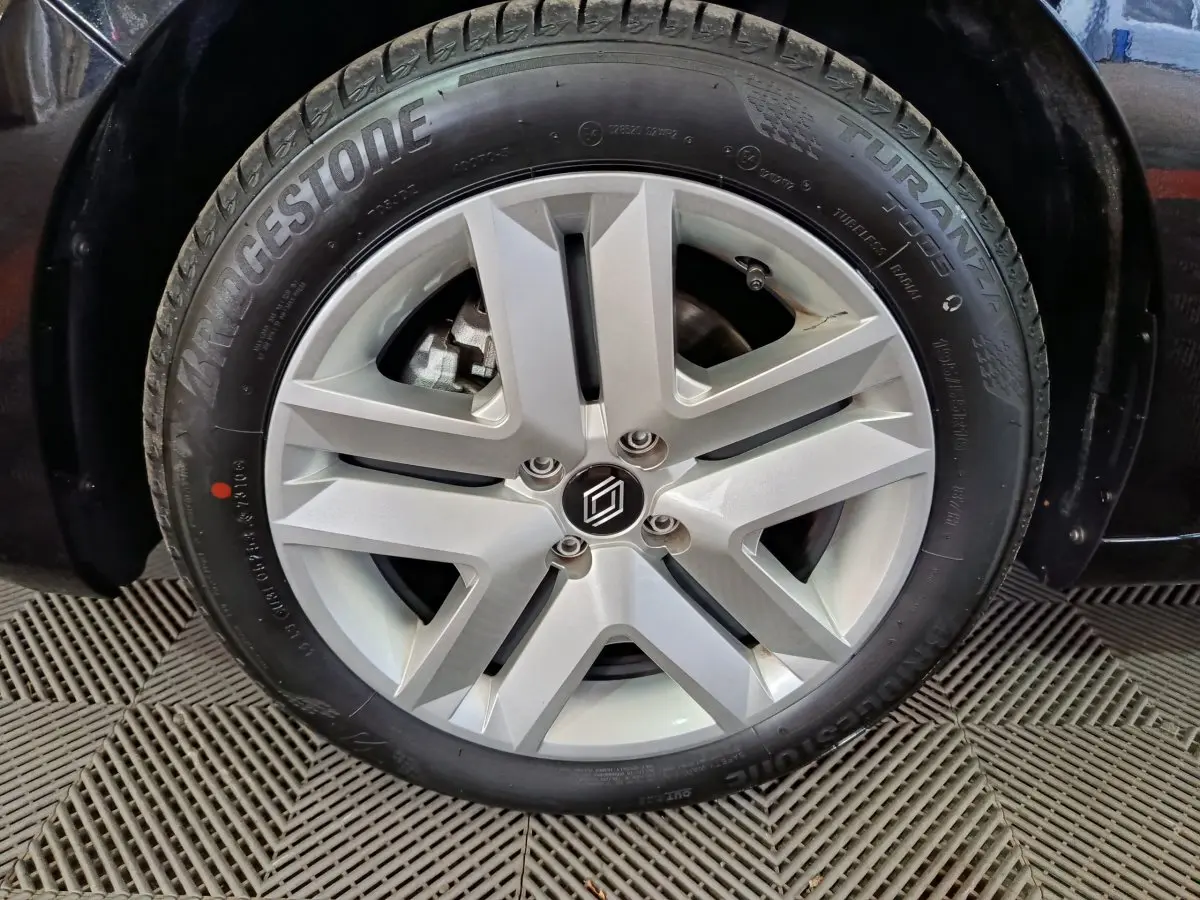 Gros plan sur la roue avant droite d’une Renault Clio noire 2025 avec jante alliage et pneu Bridgestone Turanza.