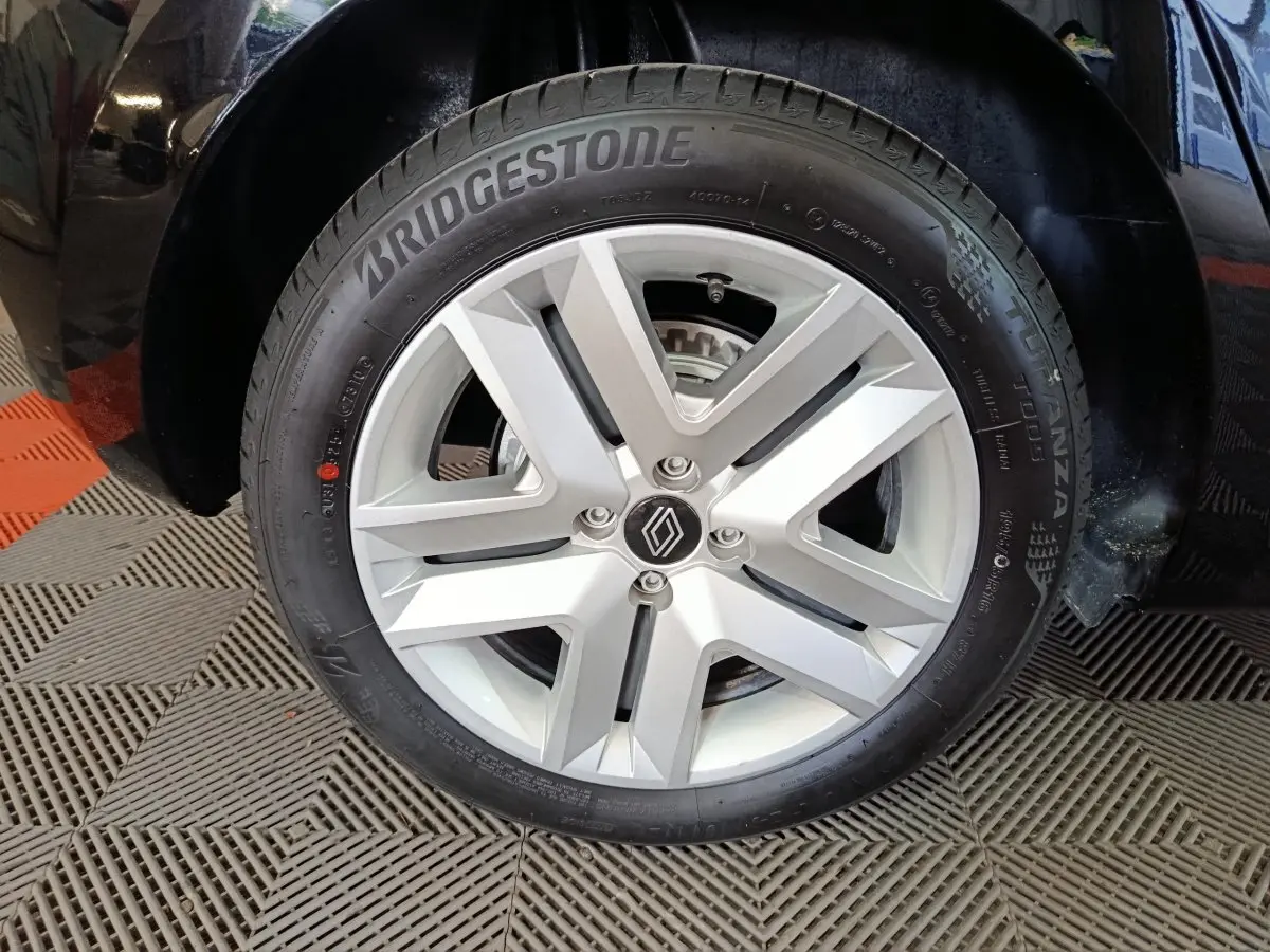 Gros plan sur la roue avant droite d'une Renault Clio noire, avec jante alliage argent et pneu Bridgestone.