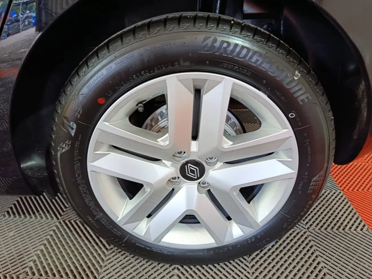 Gros plan sur la roue arrière gauche noire d'une Renault Clio Evolution Blue dCi 100, avec passage de roue visible.