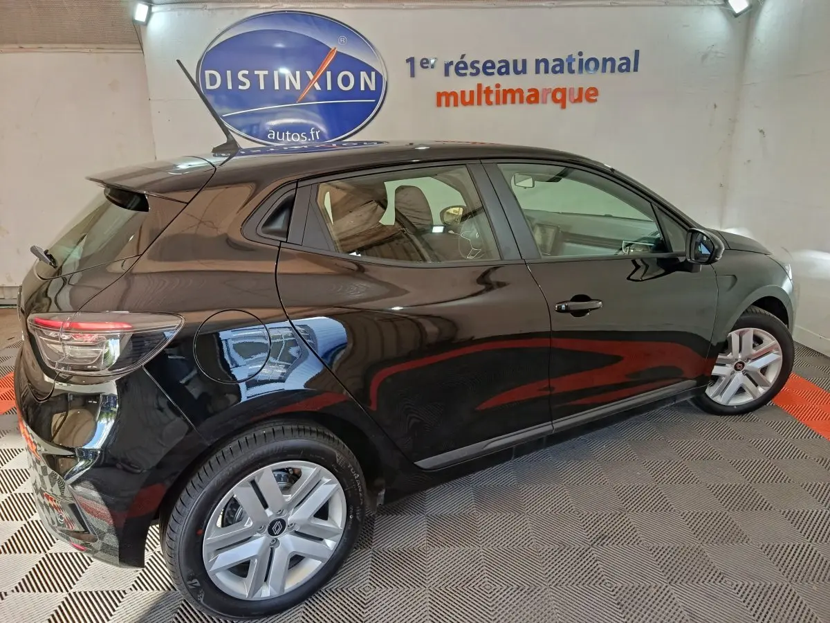 Vue latérale droite d'une Renault Clio noire 2025 garée en intérieur avec jantes argentées et vitres teintées.