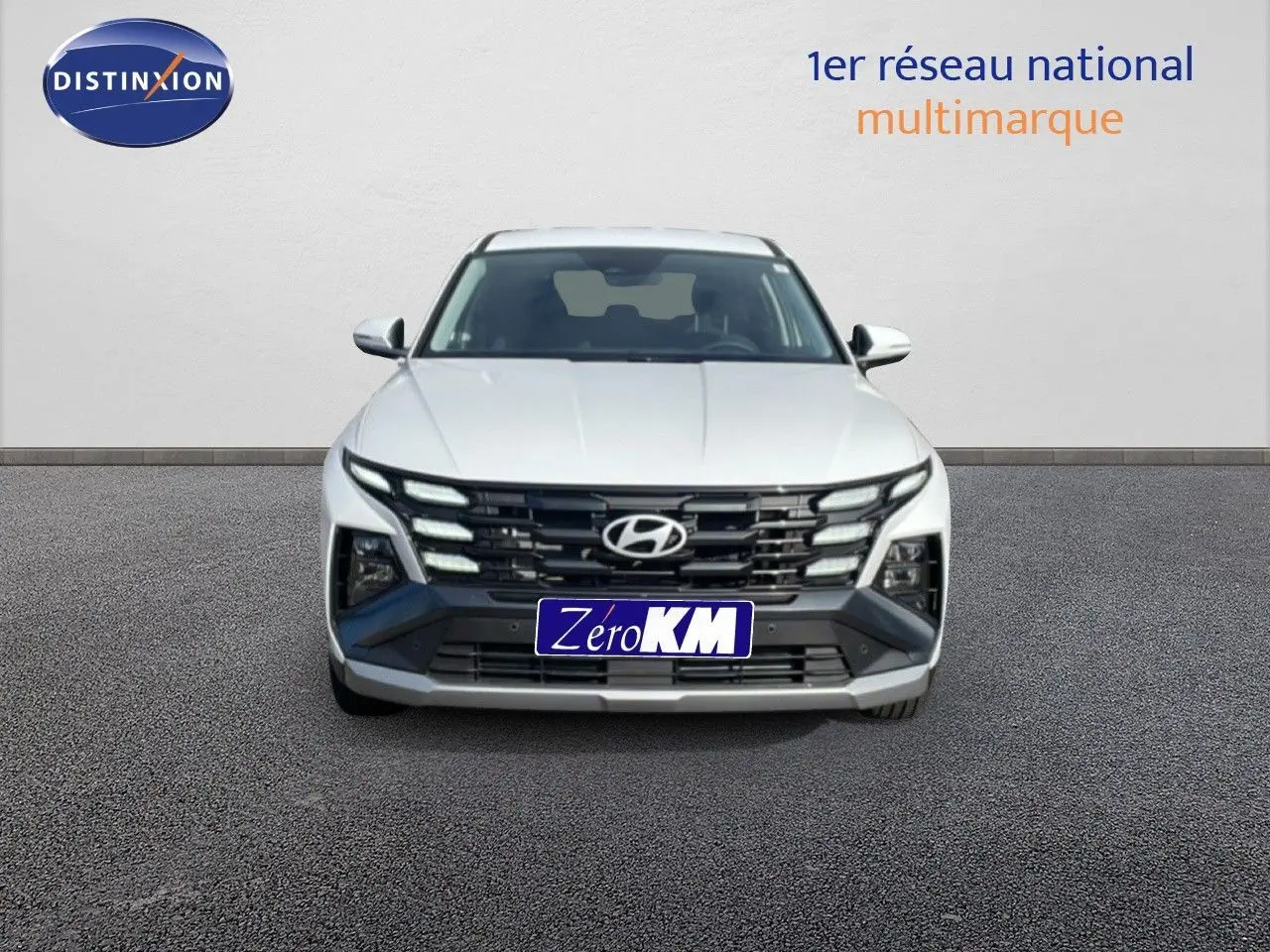 Hyundai Tucson blanc Atlas 2026 vu de face, mettant en valeur sa calandre distinctive et ses phares LED intégrés.