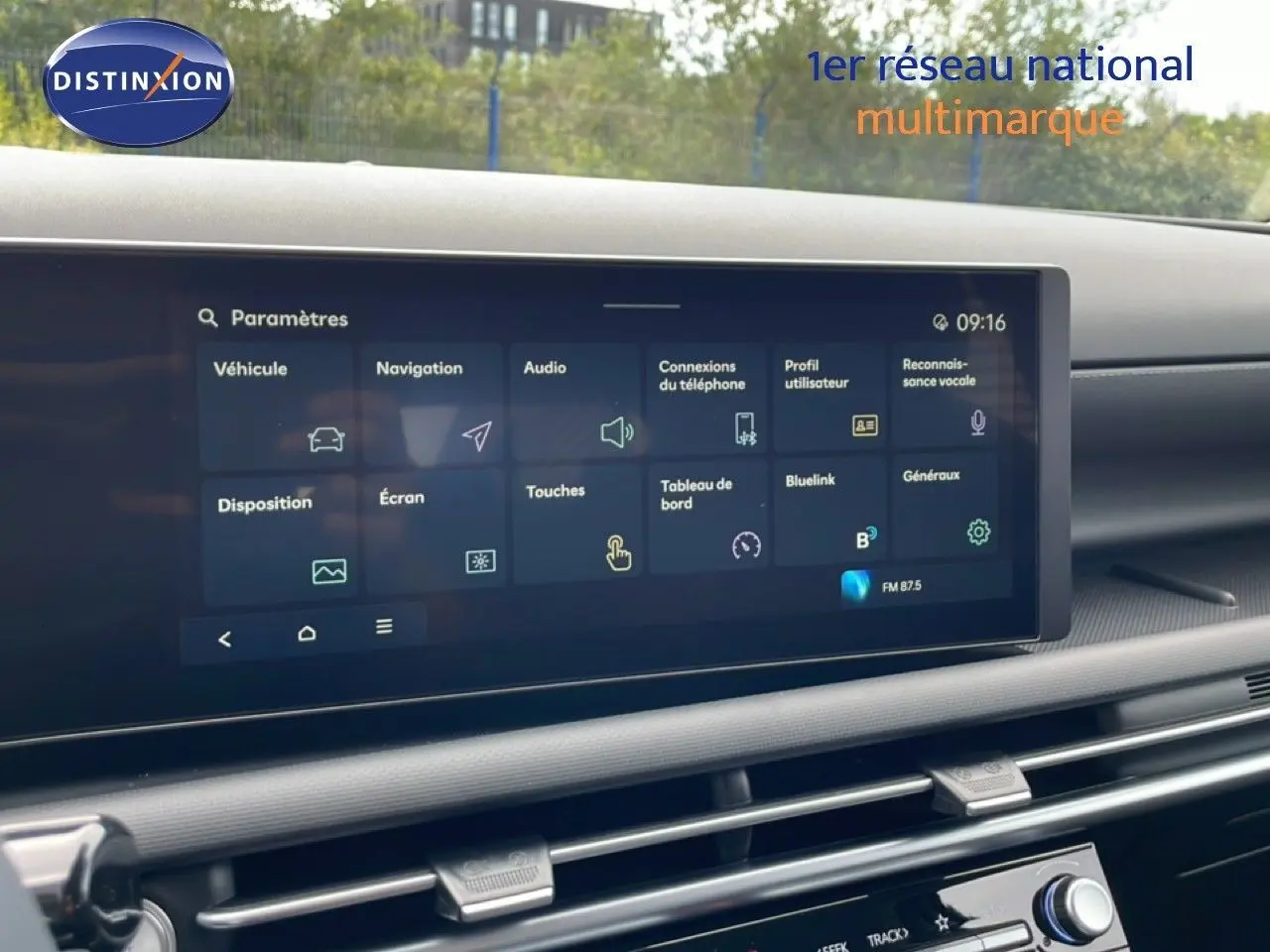 Écran tactile central du tableau de bord du Hyundai Tucson blanc, affichant le menu des paramètres multimédia.