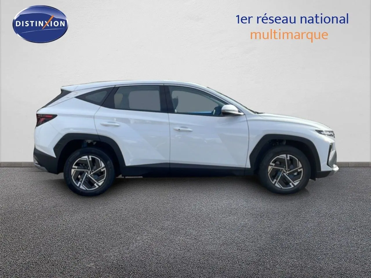 Vue de profil côté droit d'un Hyundai Tucson blanc Atlas 2026 avec jantes alliage et lignes anguleuses marquées.