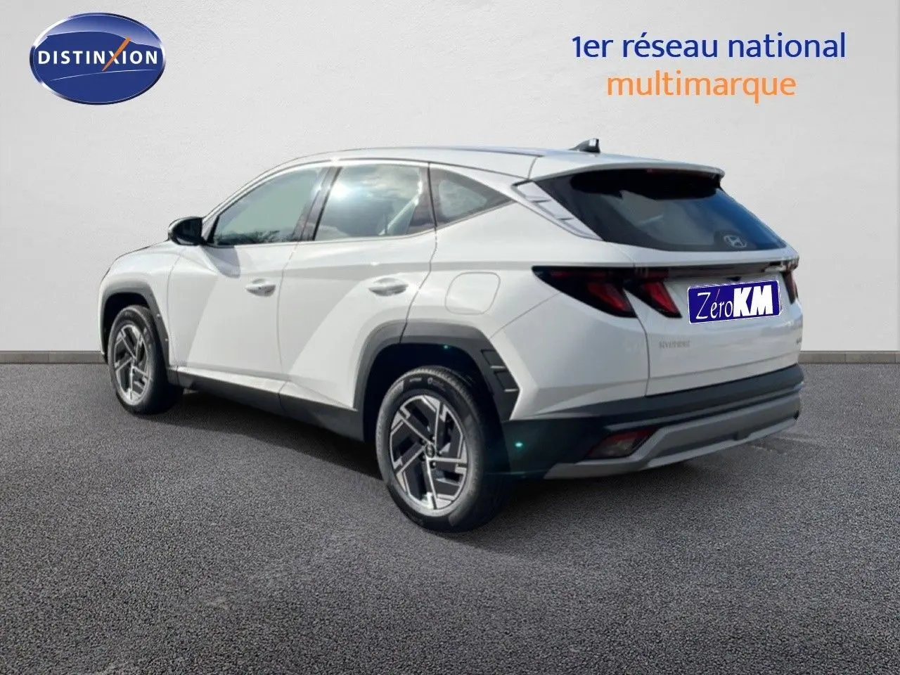 Vue 3/4 arrière droite du Hyundai Tucson blanc Atlas 2026 avec jantes bi-ton et feux arrière LED distinctifs.