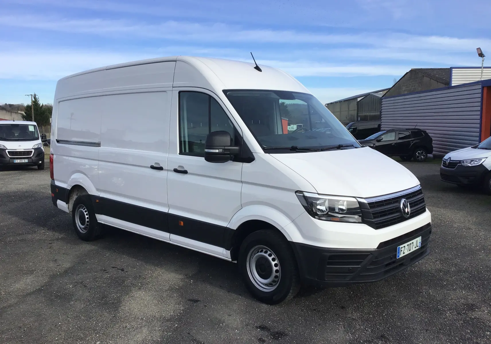 Vue 3/4 avant droite d'un fourgon Volkswagen Crafter blanc avec calandre noire et jantes acier simples.