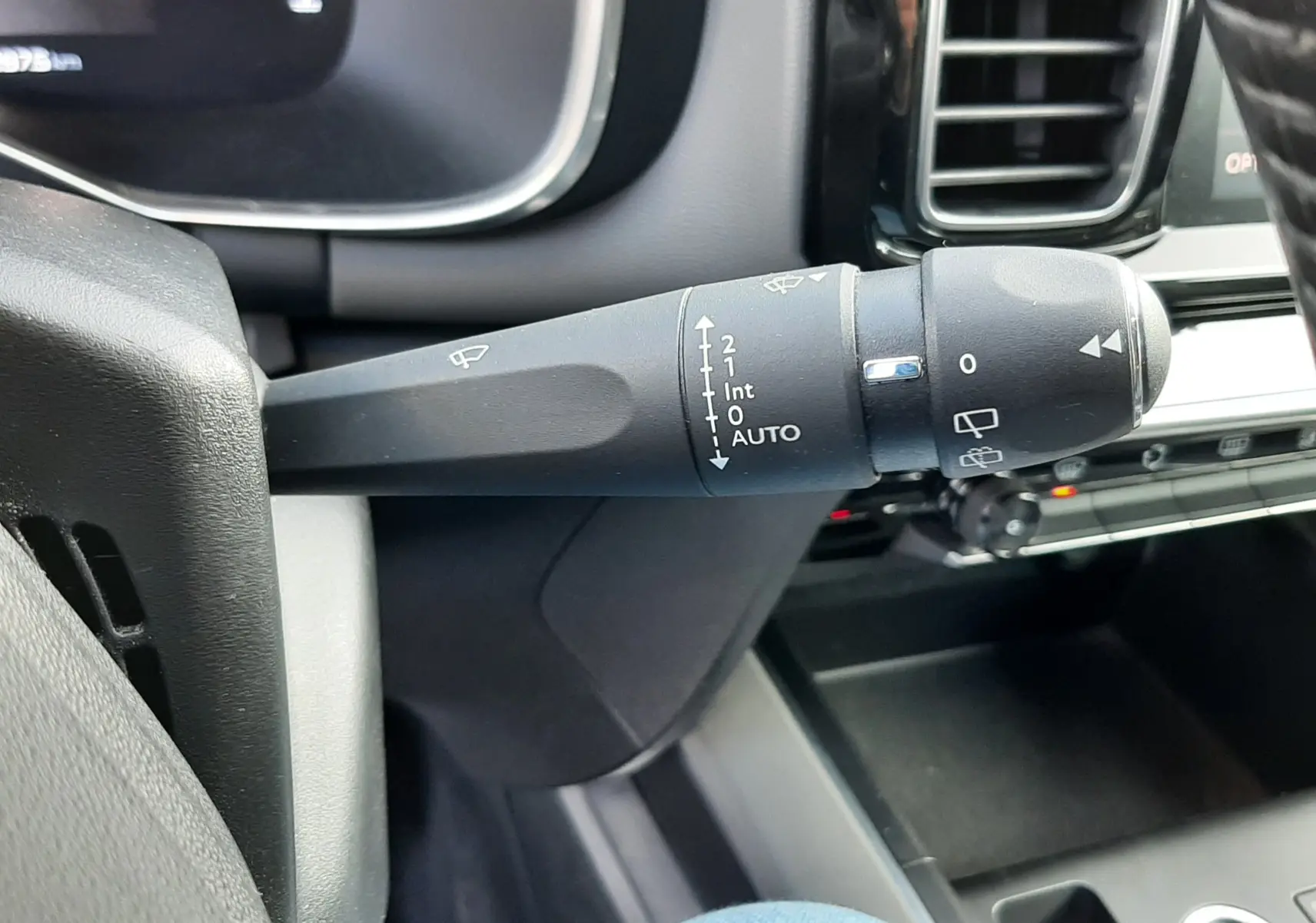 Gros plan sur la commande des essuie-glaces à gauche du volant dans l'habitacle gris du Citroën C5 Aircross 2021.
