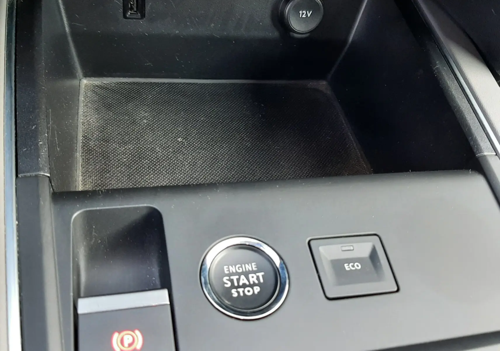 Gros plan sur la console centrale noire du Citroën C5 Aircross 2021 avec bouton start/stop, frein électrique et prise 12V.