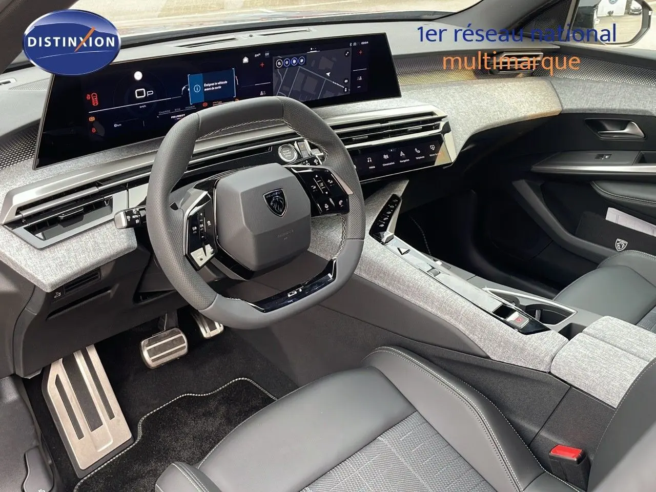 Intérieur du Peugeot 5008 Hybrid 2025 vu côté conducteur, volant compact et tableau de bord numérique moderne.