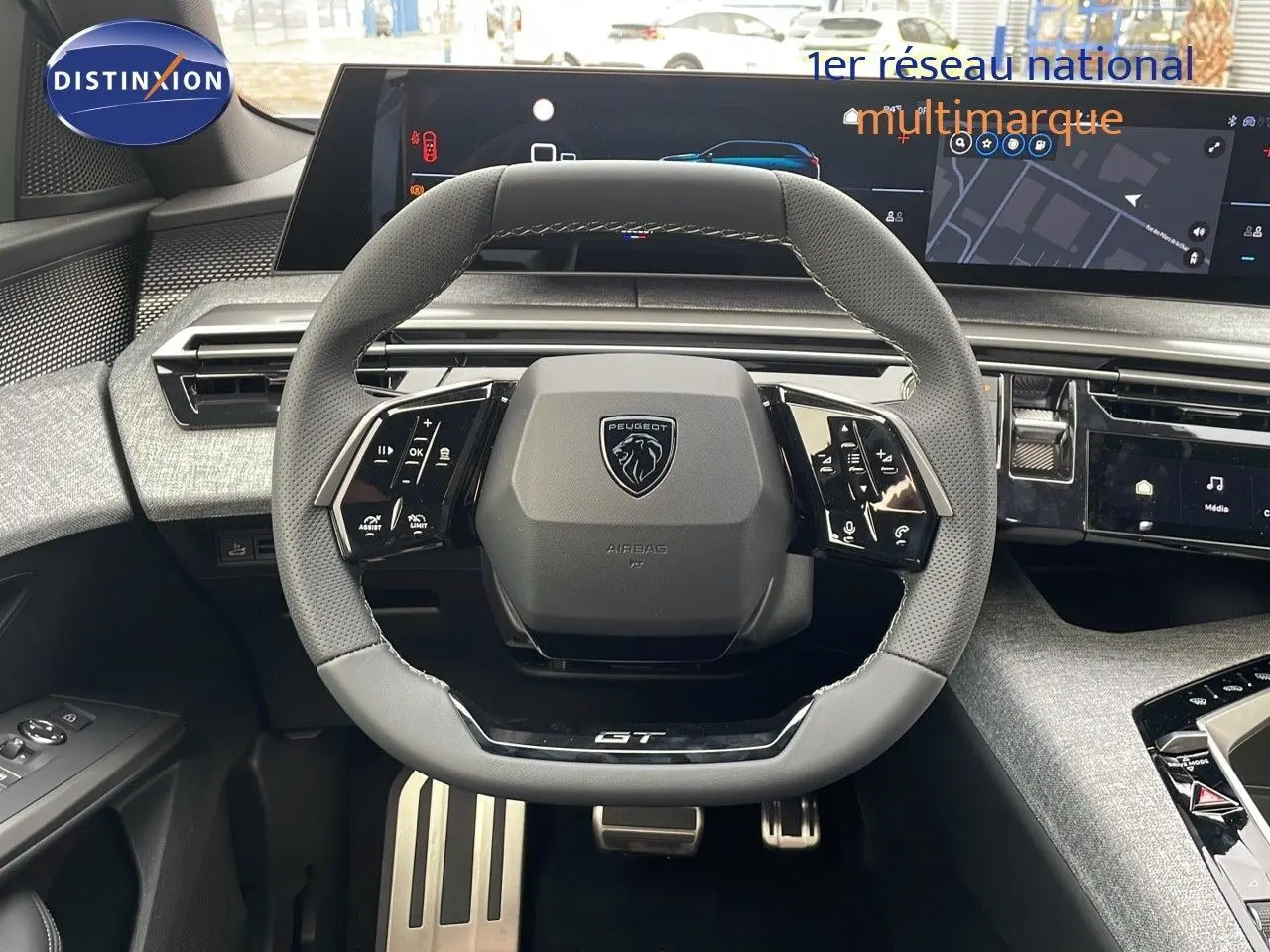 Volant GT en cuir perforé avec logo Peugeot, tableau de bord numérique et console moderne du Peugeot 5008 hybride 2025