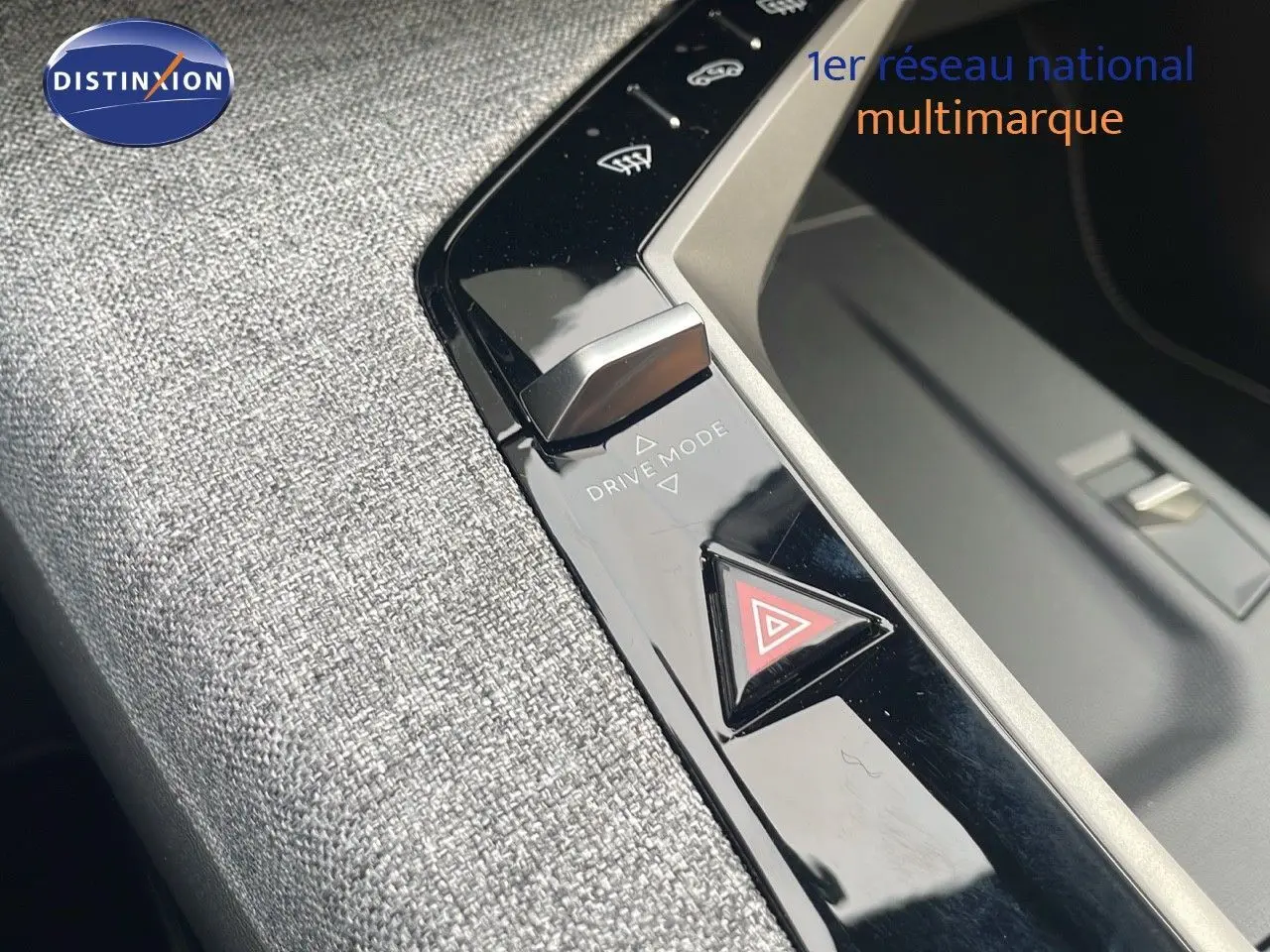 Gros plan sur la console centrale du Peugeot 5008 Hybrid 136ch GT 2025, mettant en valeur le bouton Drive Mode et le triangle de signalisation.