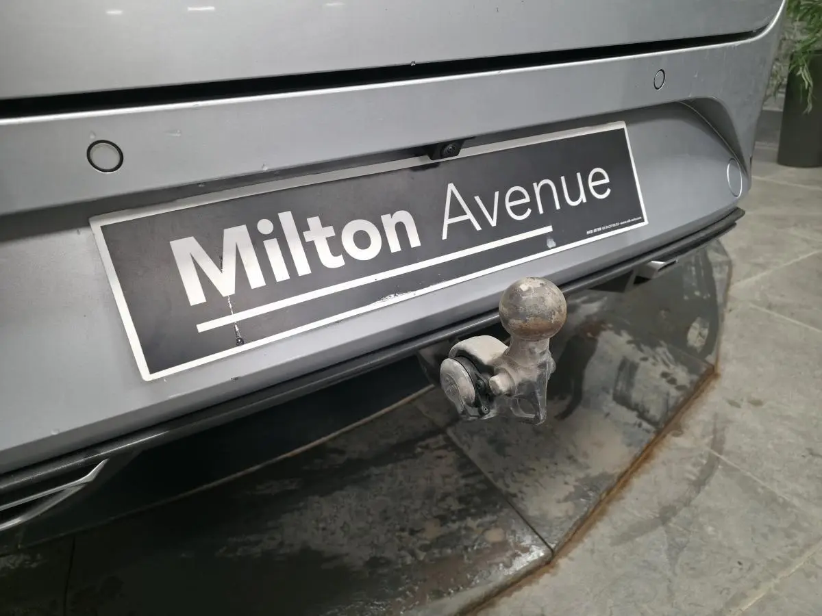 Gros plan sur le pare-chocs arrière gris d’un SEAT Leon Sportstourer avec crochet d’attelage escamotable visible.