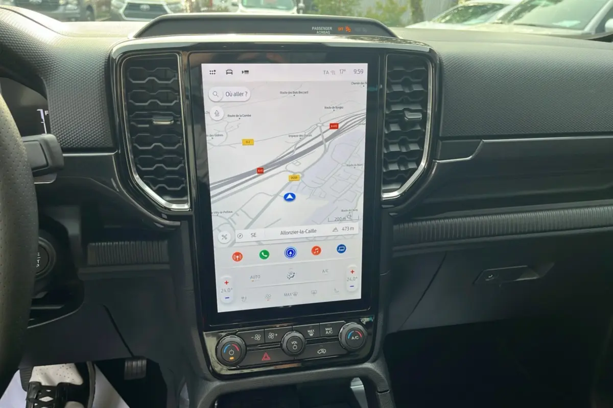 Vue centrale de l'écran tactile vertical du Ford Ranger 2025, affichant la navigation GPS et commandes climatisation.