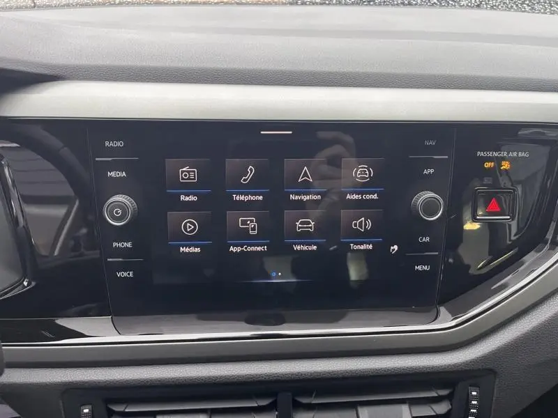 Écran tactile central du tableau de bord de la Volkswagen Polo gris, affichant le menu multimédia et navigation.