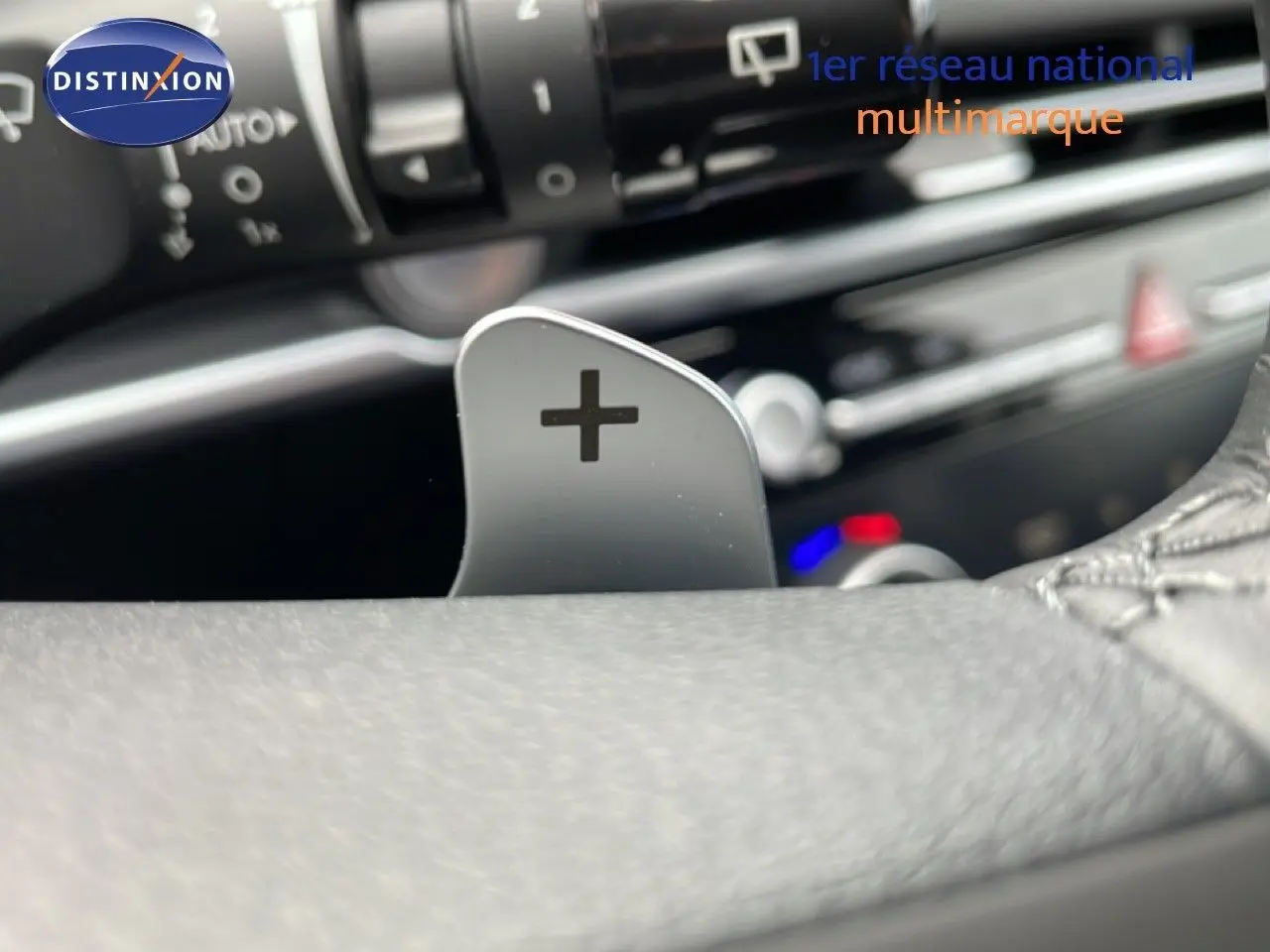 Gros plan sur la palette de changement de vitesse "+" côté droit du volant du Hyundai Tucson blanc Atlas 2026.
