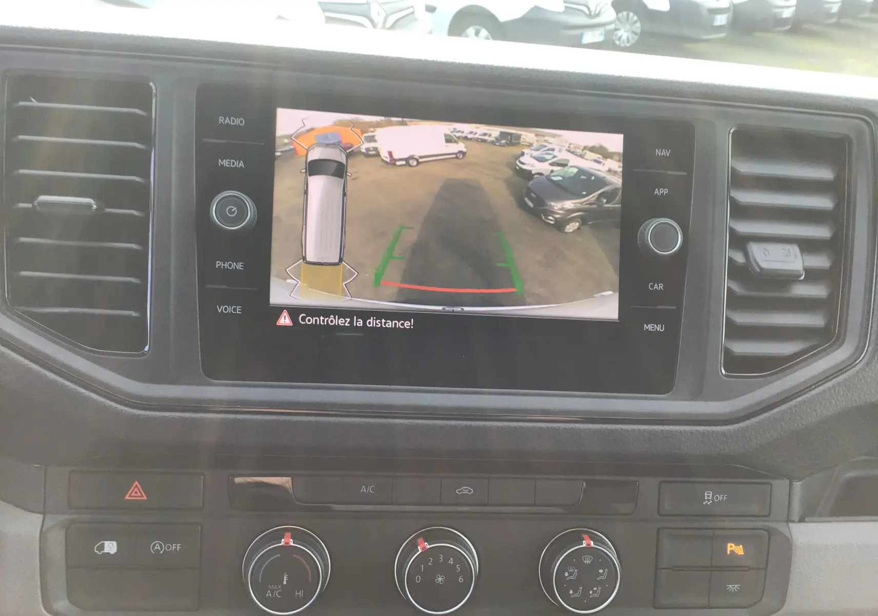 Écran central du Volkswagen Crafter 2024 montrant la caméra de recul avec vue arrière et lignes de guidage colorées.