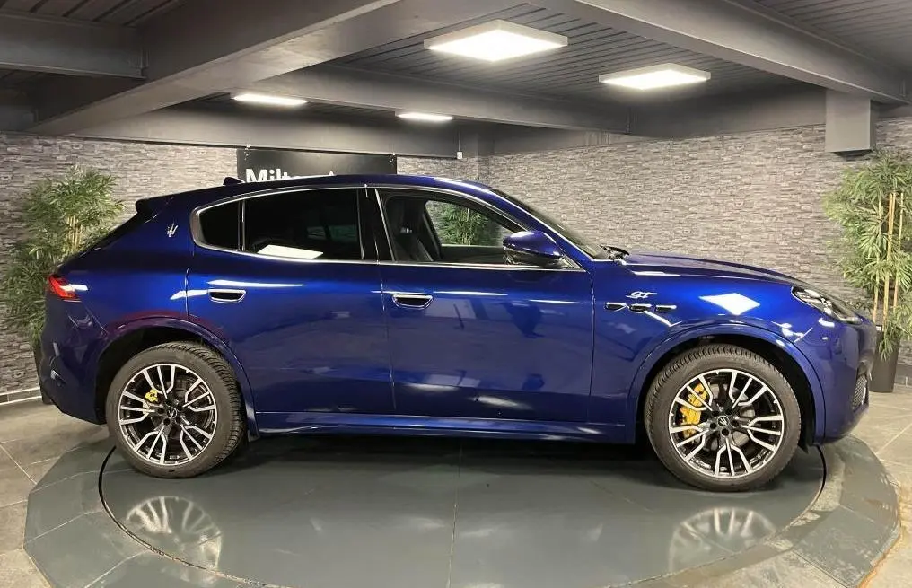 Vue latérale droite d'un Maserati Grecale bleu avec étriers de freins jaunes et jantes forgées 20 pouces gloss black.