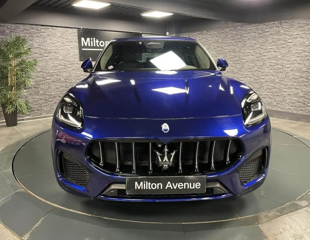 Vue frontale d'une Maserati Grecale bleu profond avec calandre verticale et logo Trident distinctif.