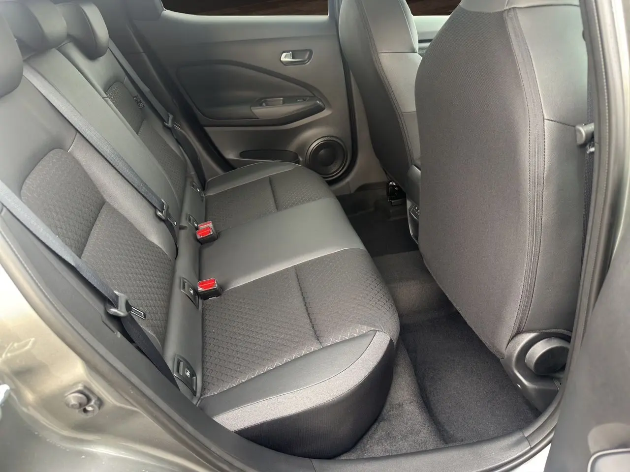 Vue intérieure côté gauche des sièges arrière en tissu noir du Nissan Juke Full Hybrid 2025 couleur gris squale.