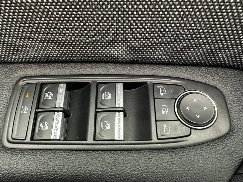 Commande des vitres électriques et réglage des rétroviseurs dans l'habitacle du Renault Captur rouge flamme 2025.