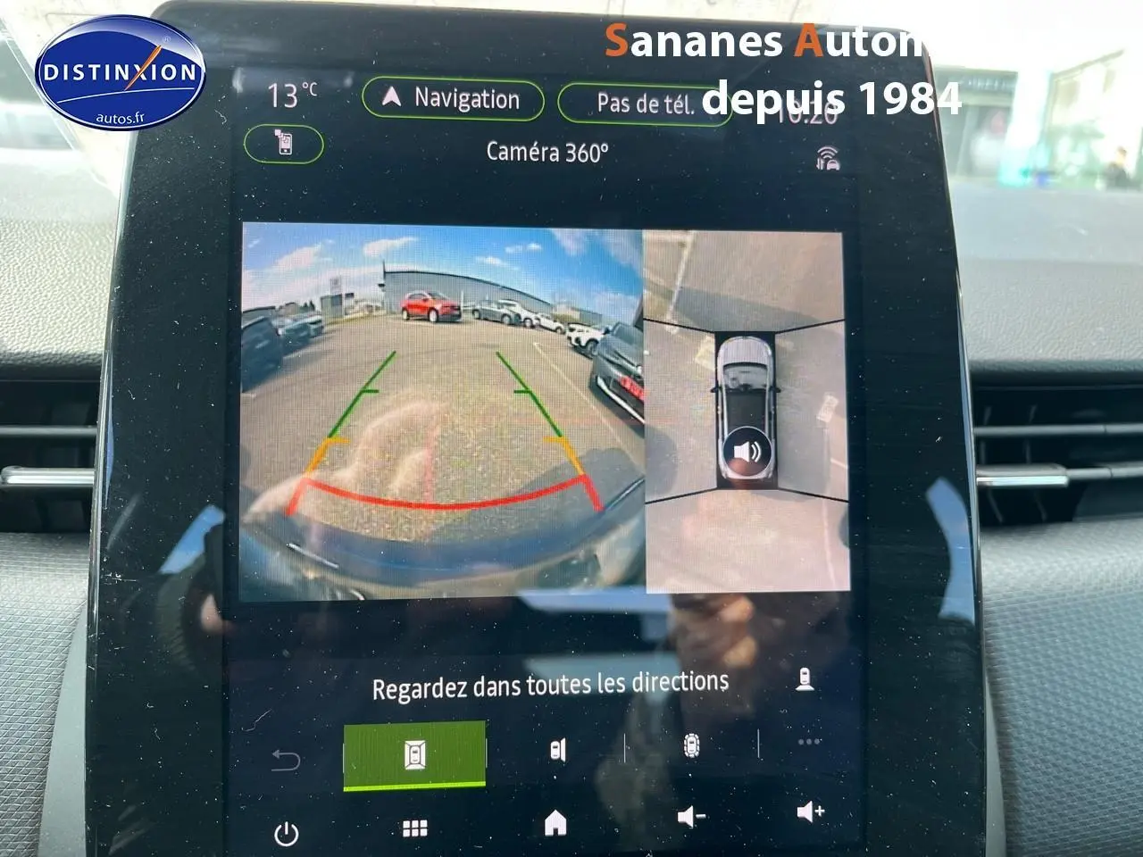 Écran multimédia montrant la caméra 360° de la Renault Clio bleu Iron, vue arrière et vue aérienne du stationnement.