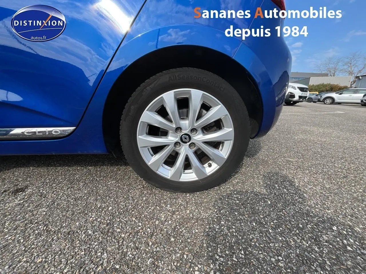 Gros plan sur la roue avant droite et la carrosserie bleu Iron d'une Renault Clio 2021 avec jante alliage diamantée grise.