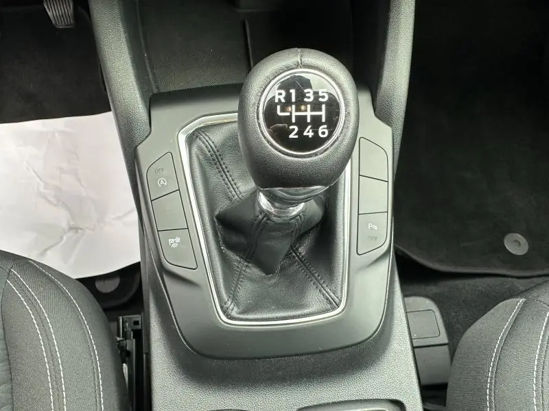 Vue rapprochée du levier de vitesses manuel 6 rapports du Ford Kuga 2024 avec cuir noir et coutures blanches visibles.