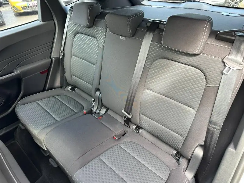 Vue intérieure de la banquette arrière en tissu noir matelassé du Ford Kuga 2024, avec ceintures de sécurité visibles.