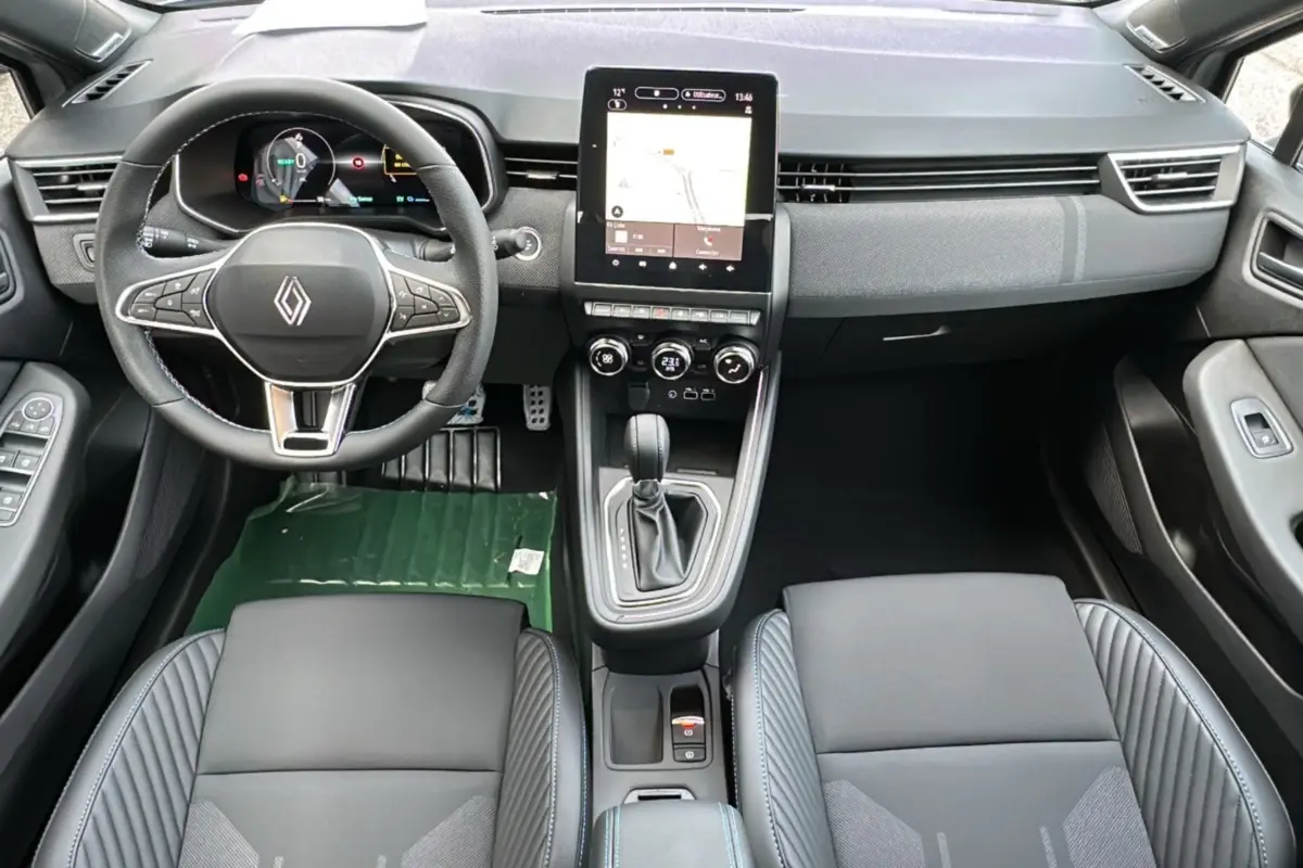Vue intérieure avant de la Renault Clio V E-Tech 145 Esprit Alpine Bose avec sièges noirs et écran tactile central allumé.