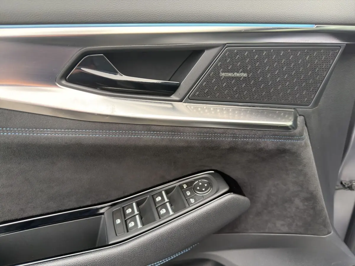 Détail de la porte côté conducteur du Renault Austral gris foncé, avec haut-parleur Harman Kardon et commandes électriques.