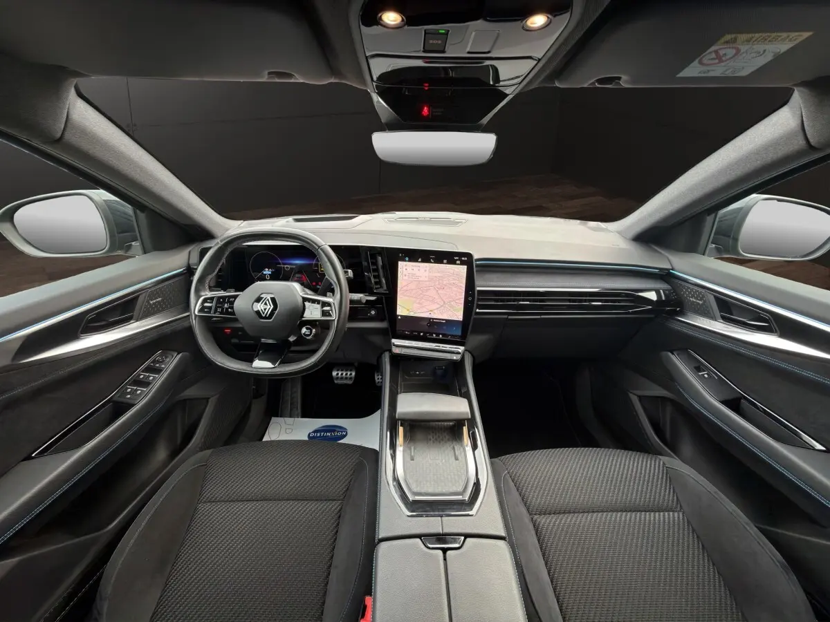 Vue intérieure avant du Renault Austral Iconic Esprit Alpine 2023, tableau de bord noir avec écran tactile central vertical.
