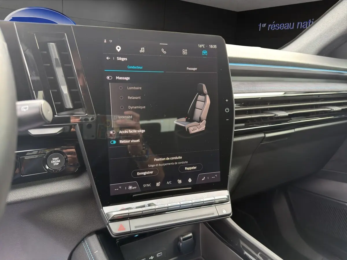 Vue intérieure du tableau de bord du Renault Austral gris foncé, avec grand écran tactile vertical et détails lumineux bleus.