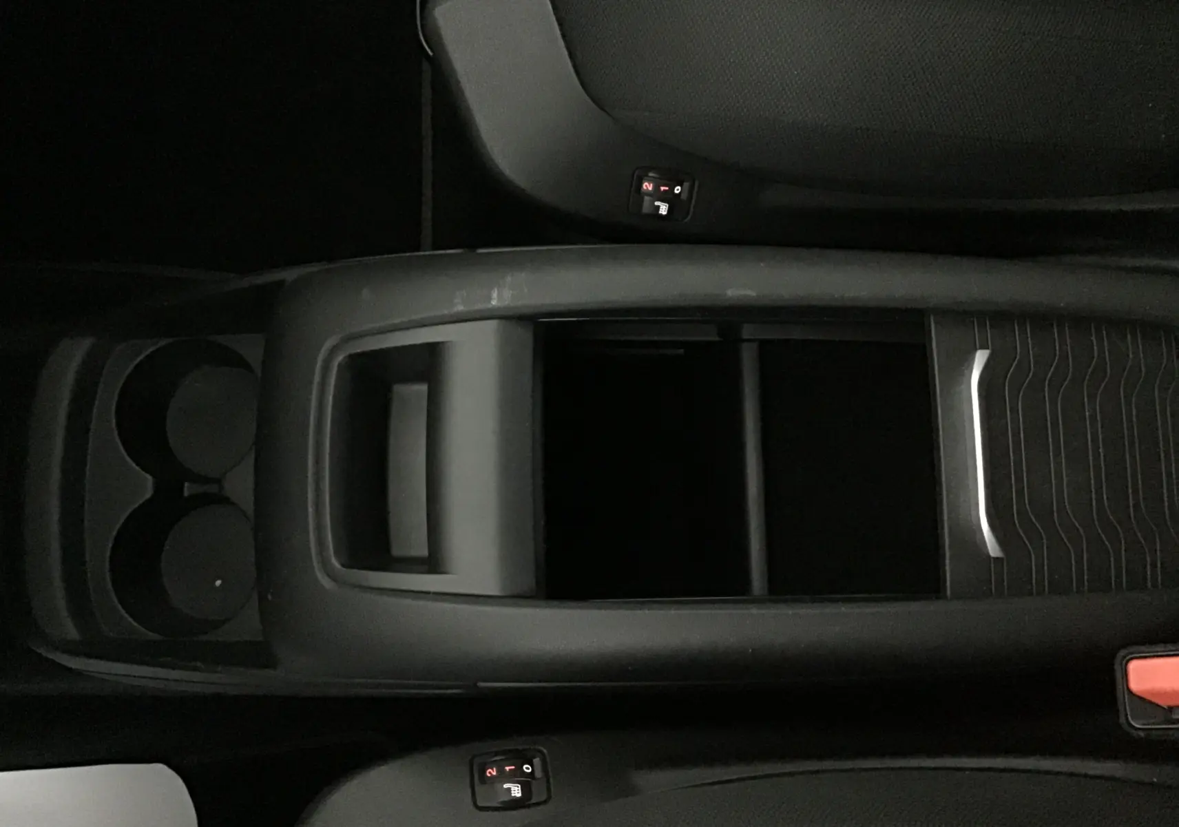 Vue plongeante sur la console centrale noire du Citroën Grand C4 Spacetourer gris, avec porte-gobelets et commandes sièges chauffants.