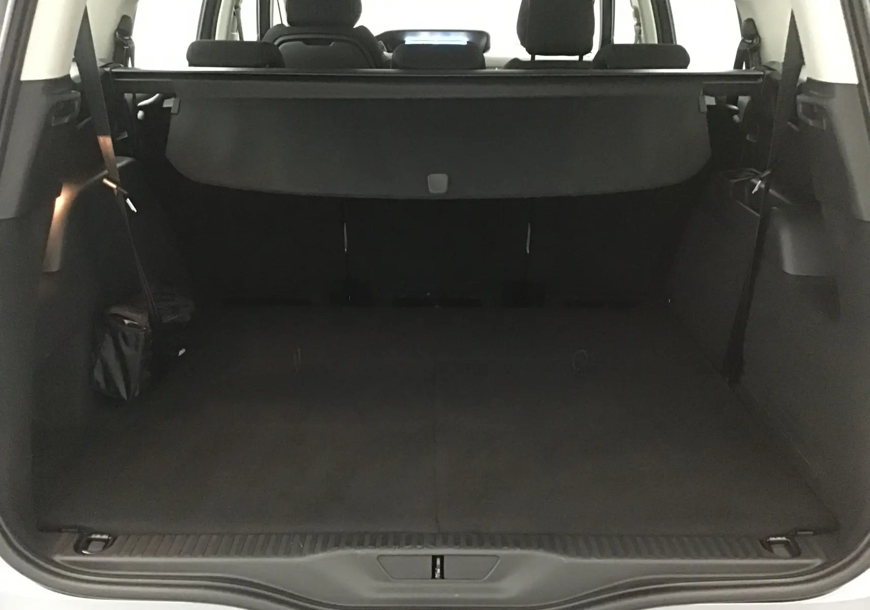 Coffre ouvert vu de l'arrière du Citroën Grand C4 Spacetourer gris Artense, montrant l'espace de chargement et la plage arrière.