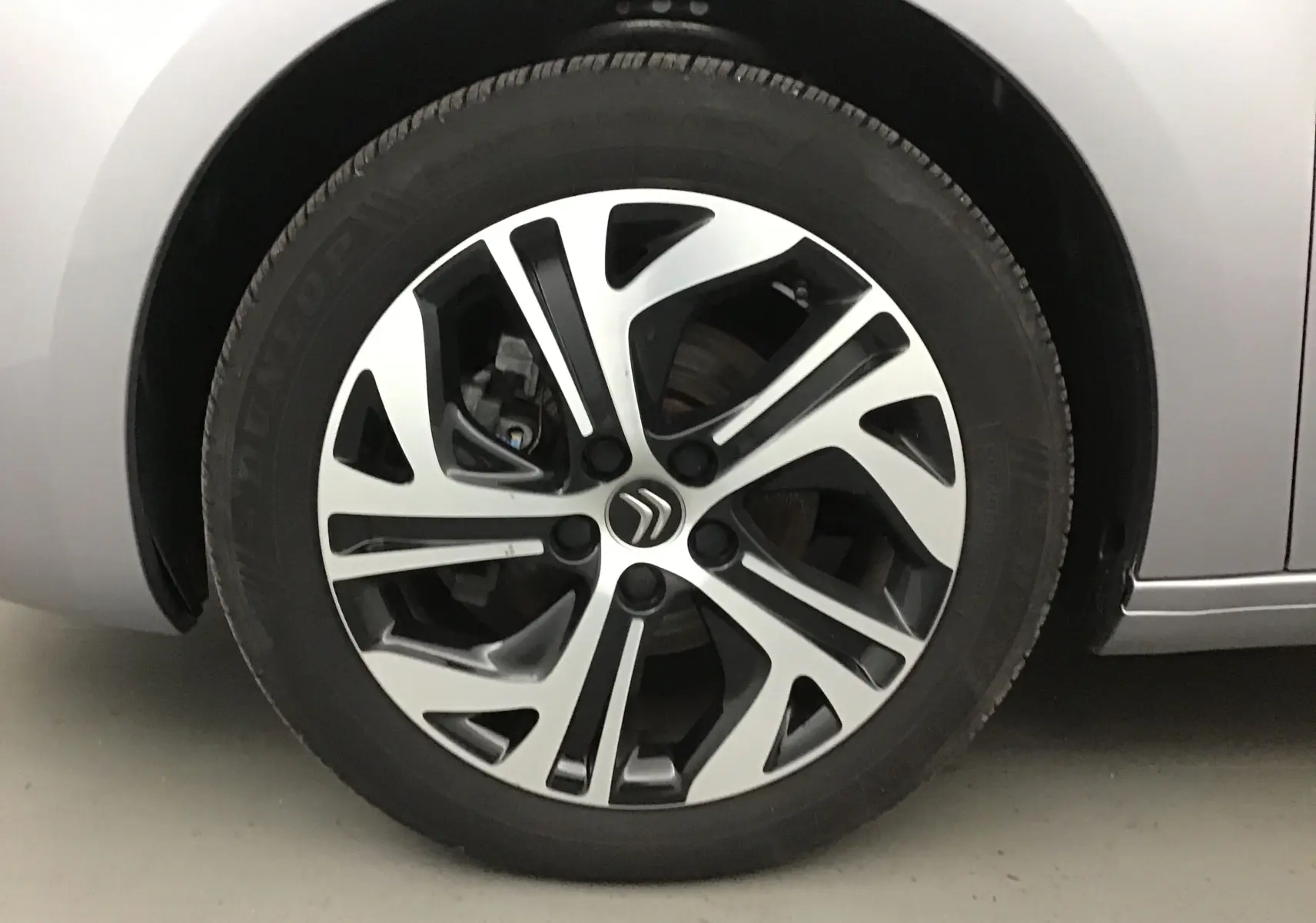 Gros plan sur la jante alliage bicolore du côté gauche d'un Citroën Grand C4 Spacetourer gris Artense 2021.